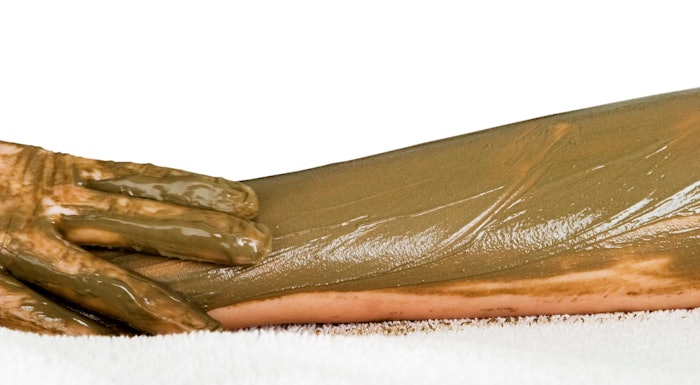 Hands rubbing a treatment on a leg