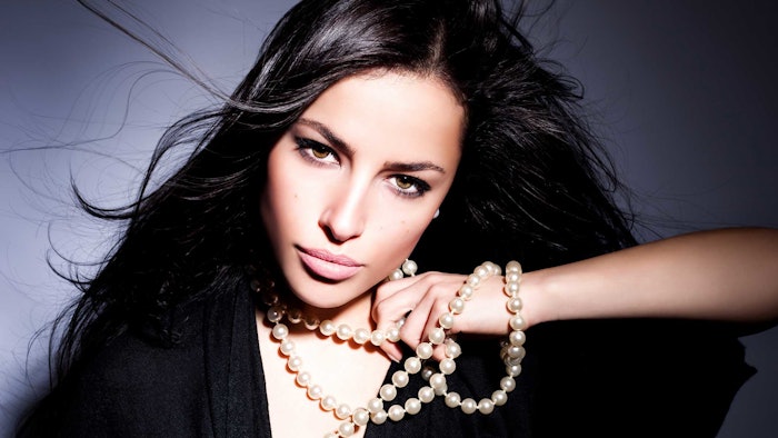 beautiful brunette radiant skin wearing pearls long hair blowing