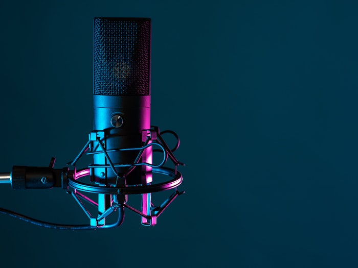 Professional studio microphone. Condenser microphone on a dark background. It is designed for podcasting. Microphone as a symbol for recording audio podcasts. Recording audio podcasts in studio