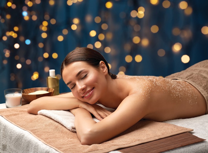 Woman having a salt scrub in the spa during the holidays