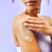 Beauty studio, shoulder or person with cream application, skin treatment cosmetics or self care wellness. Sunscreen, body hydration or model dermatology creme, ointment or lotion on purple