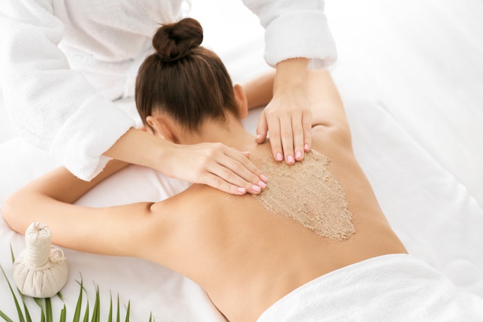 Woman getting a body scrub service at the spa