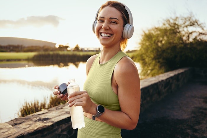Happy sportswoman taking a water break outdoors