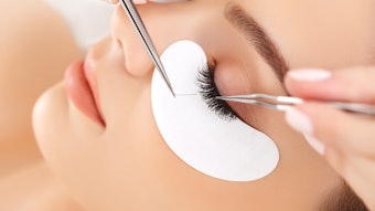 Woman getting eyelash extensions in the spa
