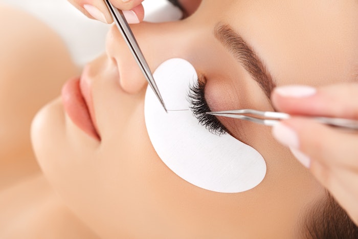 Woman getting eyelash extensions in the spa
