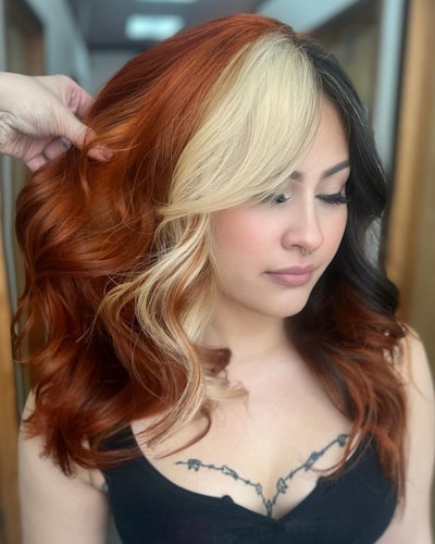 Calico hair trend with platinum blonde and black face framing strands and a red, copper base.