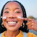 Young Black Woman Outside Applying Sunscreen To Cheeks Adobe Stock 672065582 (1)
