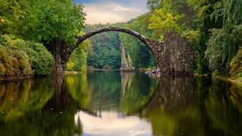 Autumn, cloudy evening over Devil's bridge in the park Kromlau, Germany