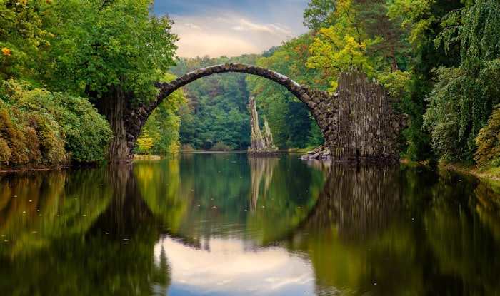 Autumn, cloudy evening over Devil's bridge in the park Kromlau, Germany