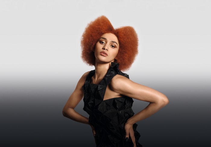 Model with Orange Glow colored hair, Goldwell's Color of the Year for 2025.