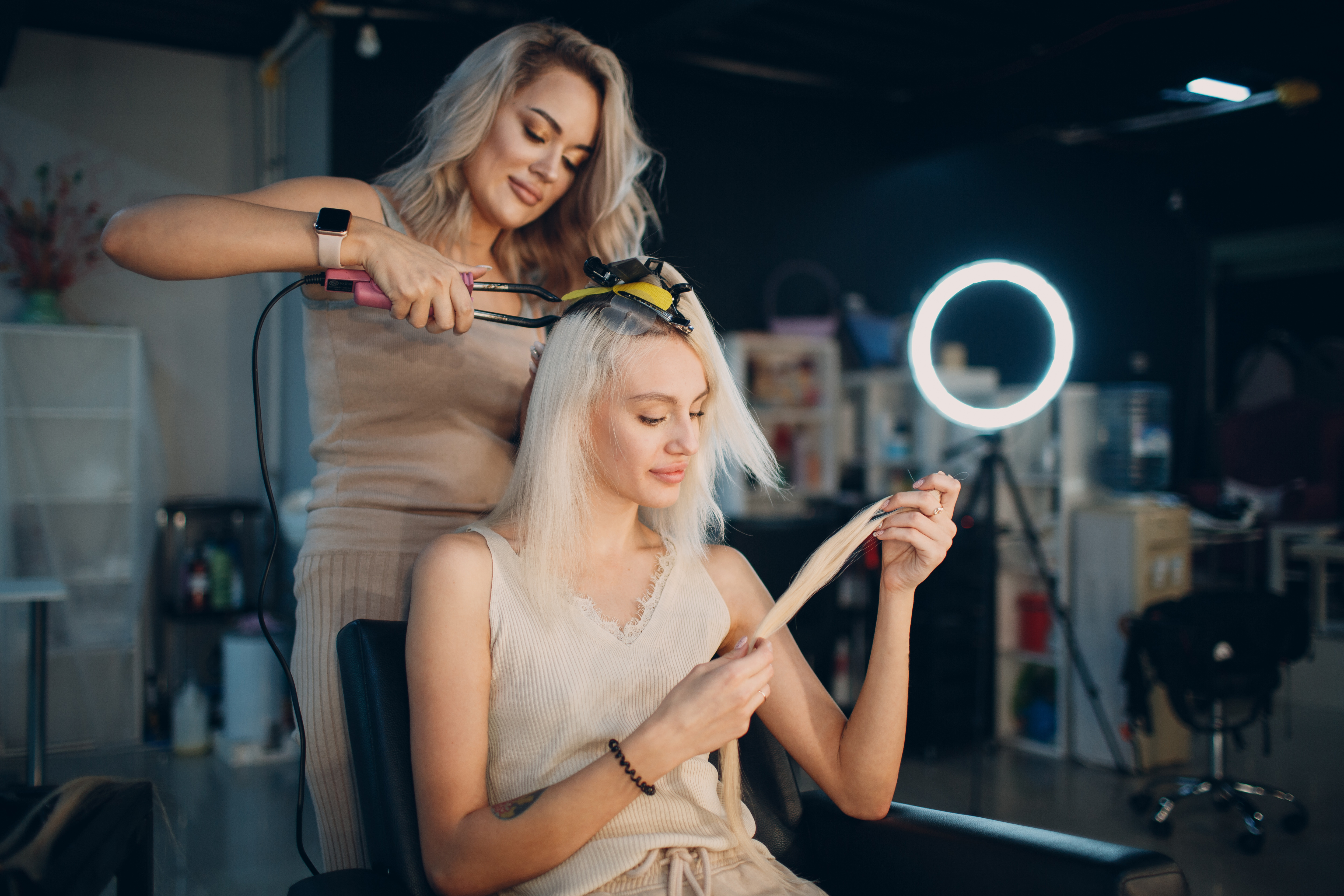 Hairstylist applying hair extensions to a client.