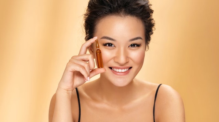 Beautiful Asian Woman Holding Skin Care Ampoule