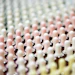 Rows of pastel pink and white textured cylindrical objects with rounded tops