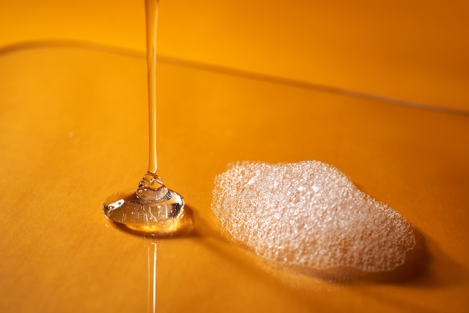 Clear Liquid And Foam On Orange Background I Stock 1448099587 Med (1)