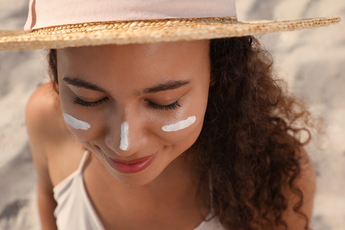 Woman In A Hat At Beach Sunscreen On Face Adobe Stock 458234417