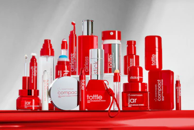Red and white cosmetic product collection featuring skincare bottles, jars, and containers with branded packaging