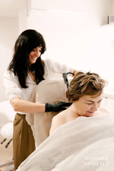 Massage therapist performing back treatment on relaxed client in bright wellness clinic