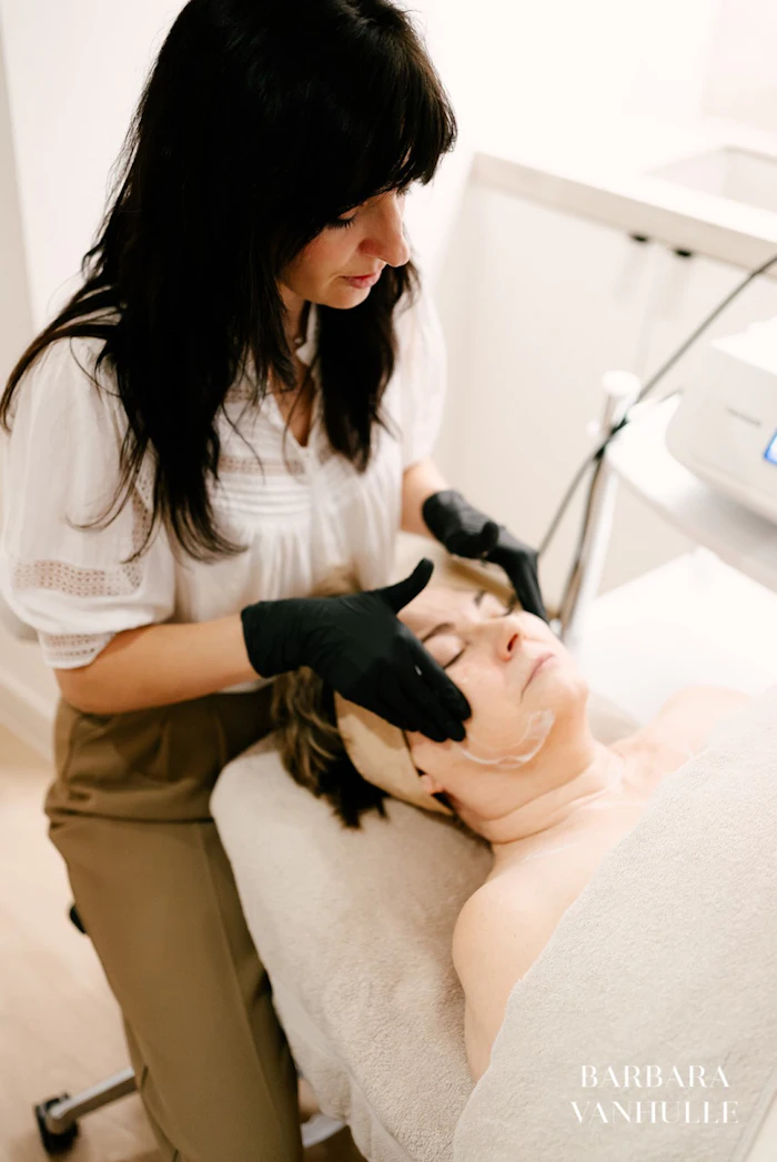 Skincare specialist performing facial treatment on client in modern spa setting