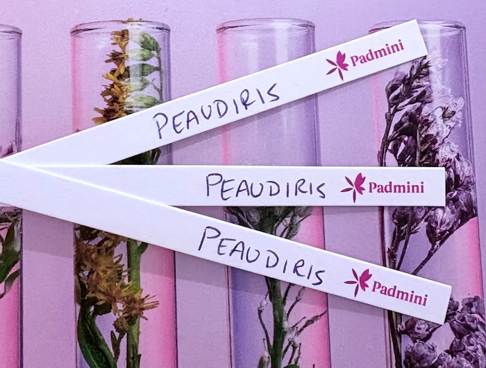 Padmini branded ribbons with botanical specimens in glass containers on purple background