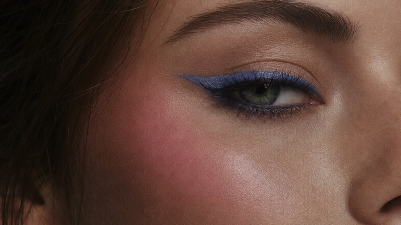 Close-up of eye with blue eyeshadow makeup and defined brow