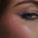 Close-up of eye with blue eyeshadow makeup and defined brow