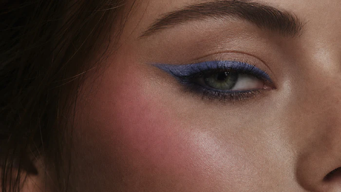 Close-up of eye with blue eyeshadow makeup and defined brow