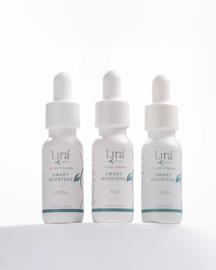 Three white dropper bottles of Lira Clinical Smart Boosters serums with teal accents, labeled PDRN+, TXA+, and NAD+