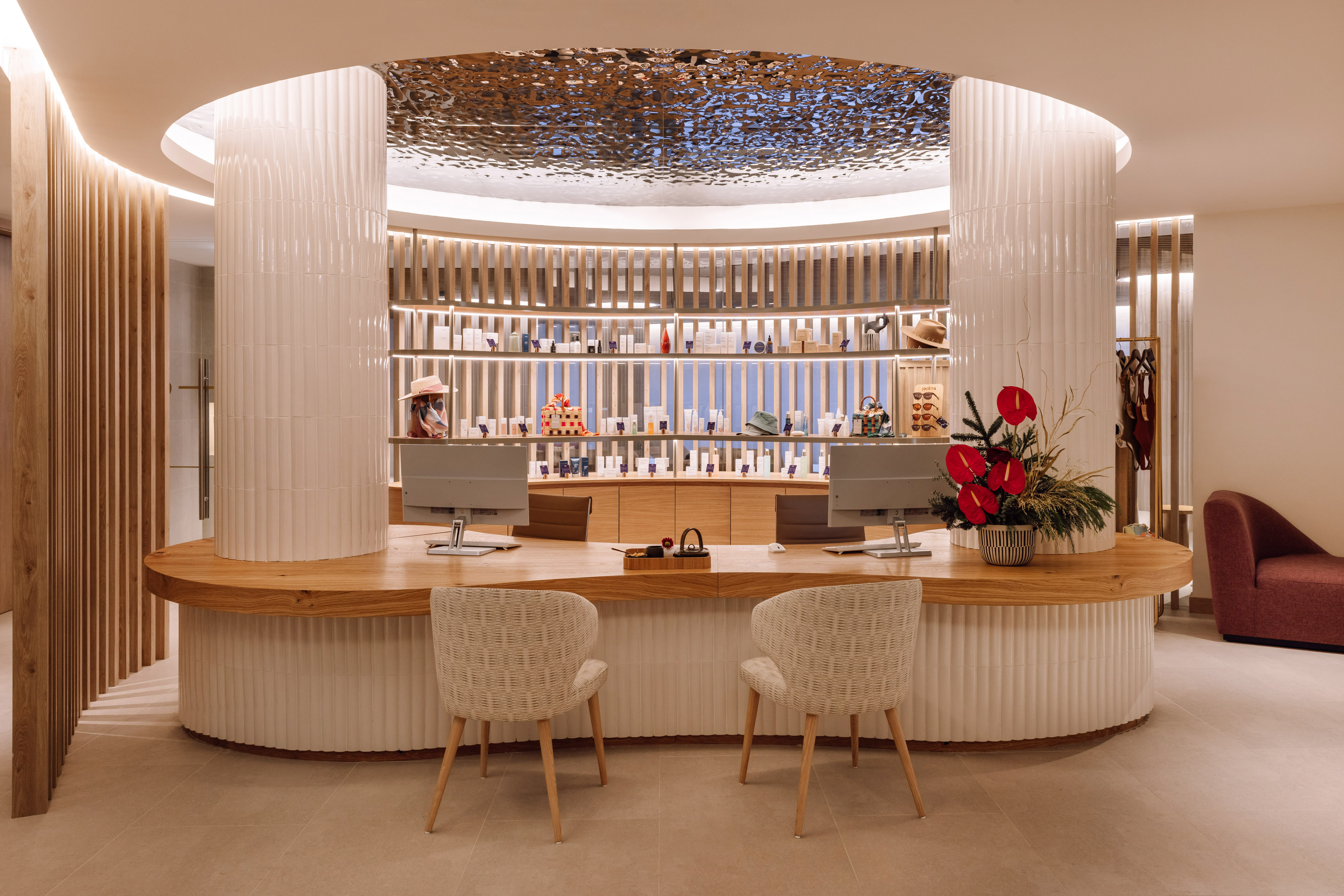 Luxury jewelry store interior with curved white counter, wooden accents, and illuminated display shelving