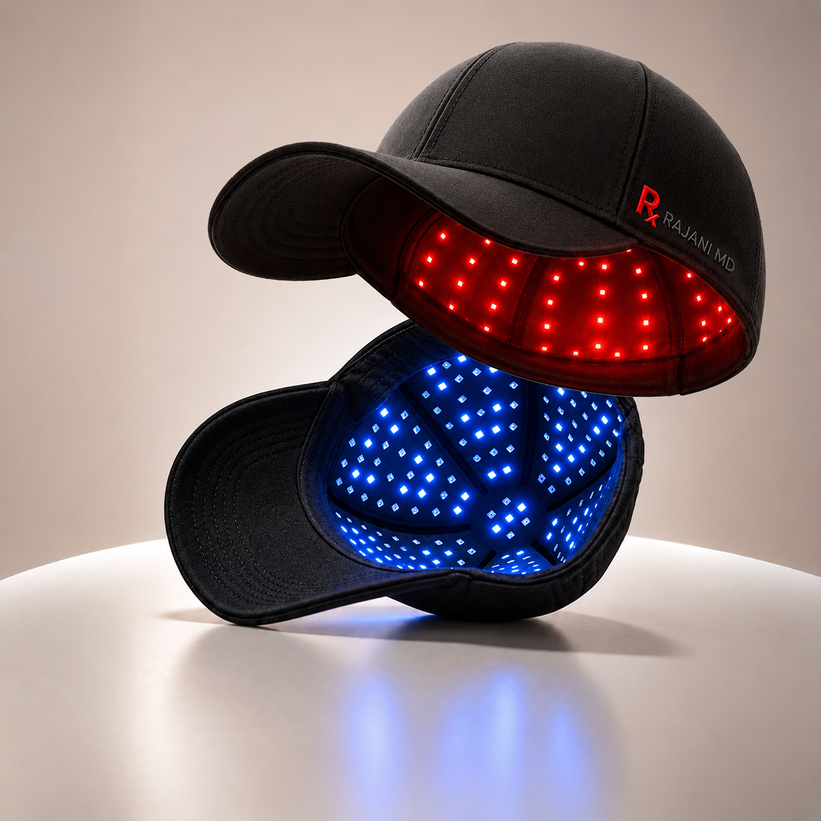 Stacked LED light therapy baseball caps with red and blue illuminated panels and Rajani MD branding